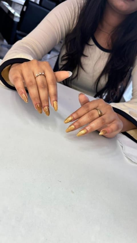 Metallic gold cat-eye almond nails with glossy finish